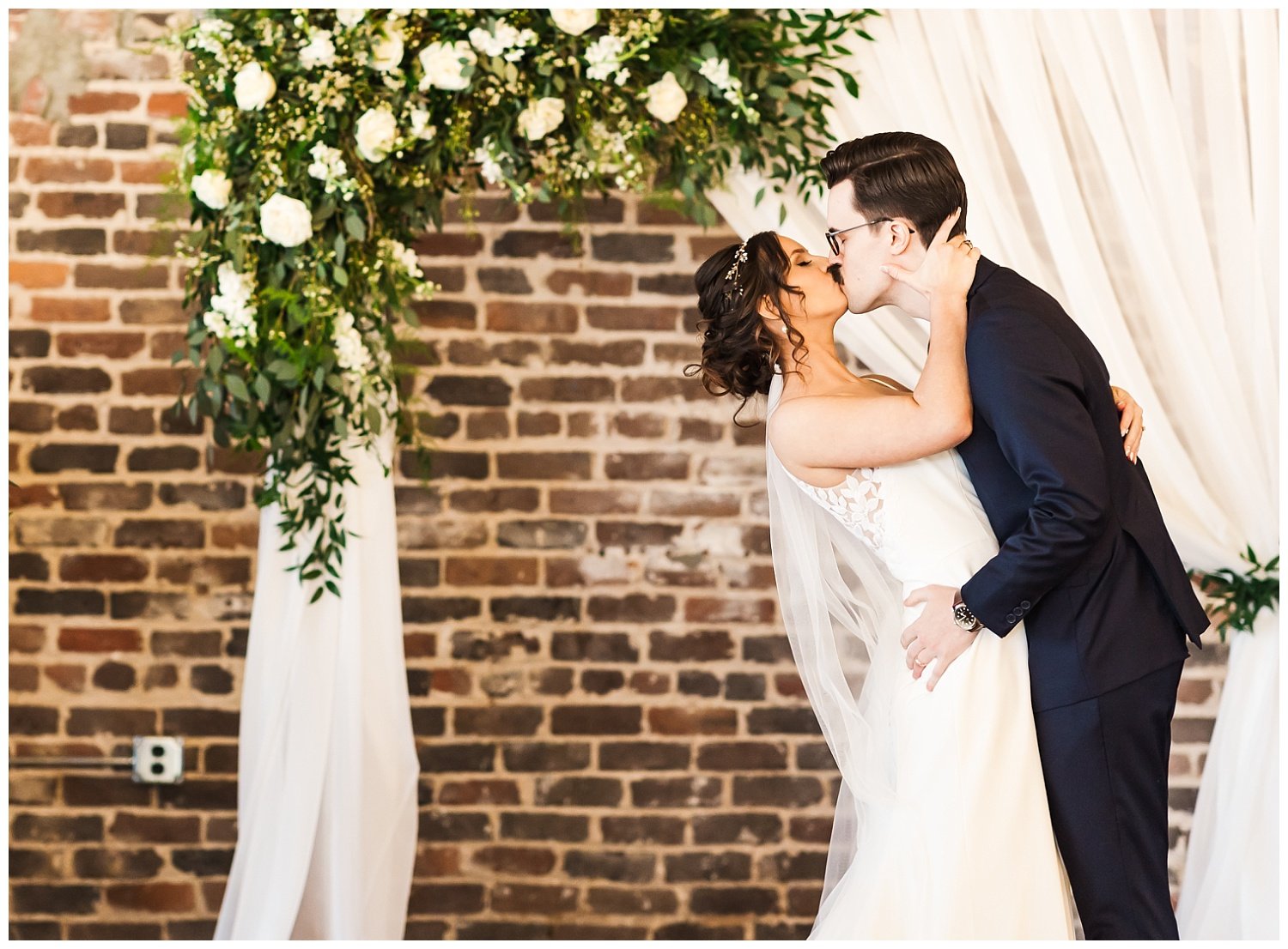 bride and groom share kiss during ceremony