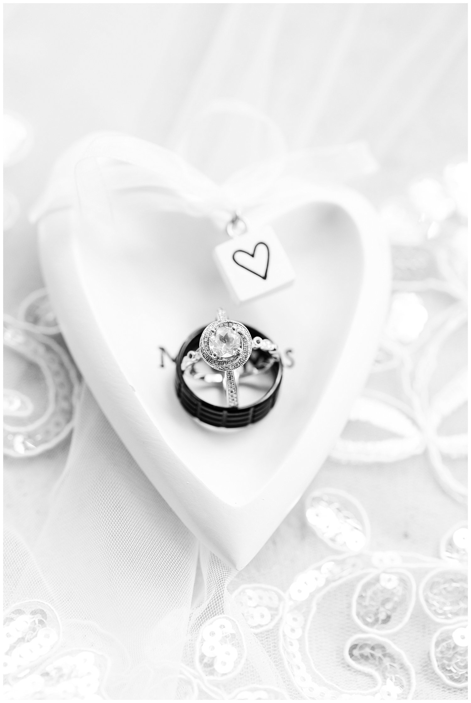 wedding rings sitting in a heart shaped dish 