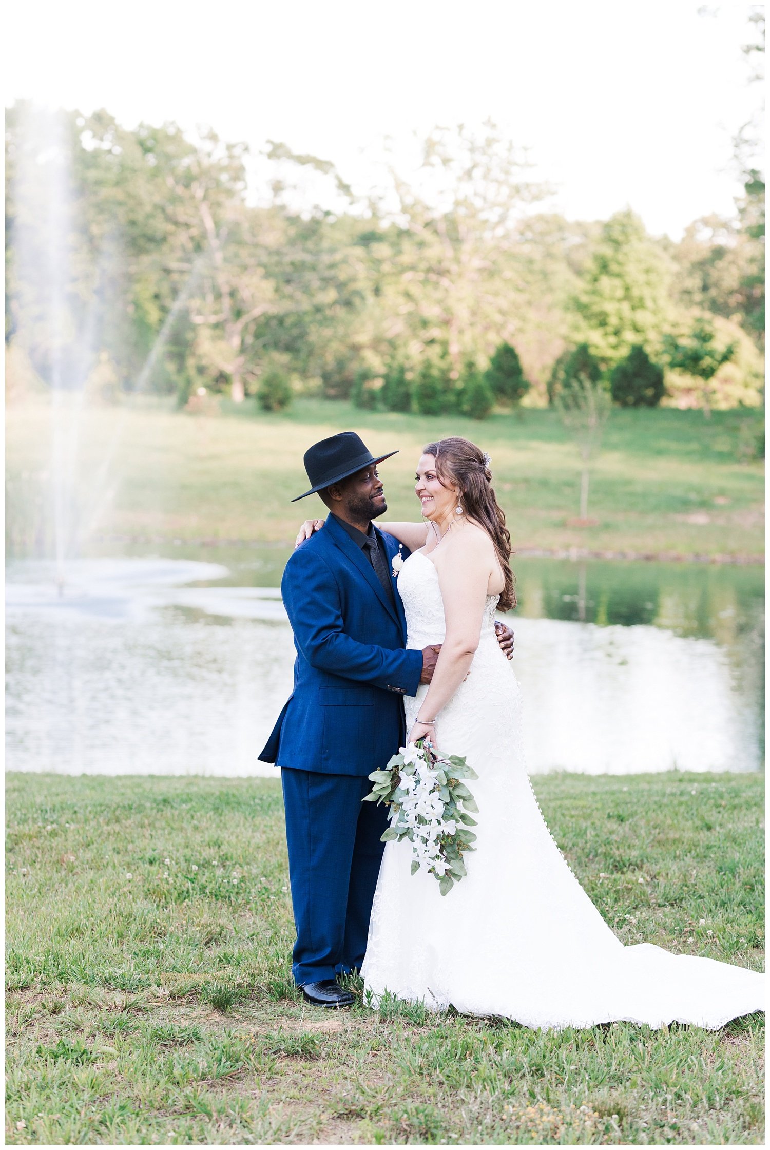 bride and groom posing by the pond at Mountain Heights Venue