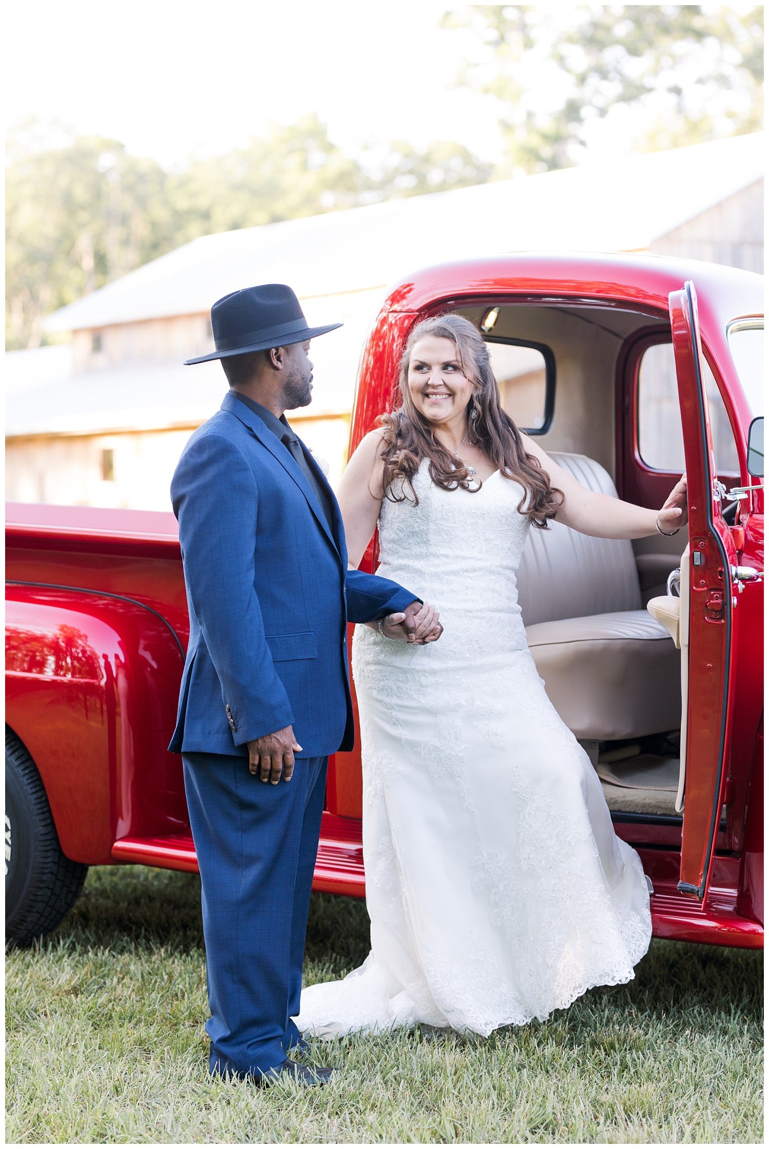 bride and groom posing with red truck at Mountain Heights Venue