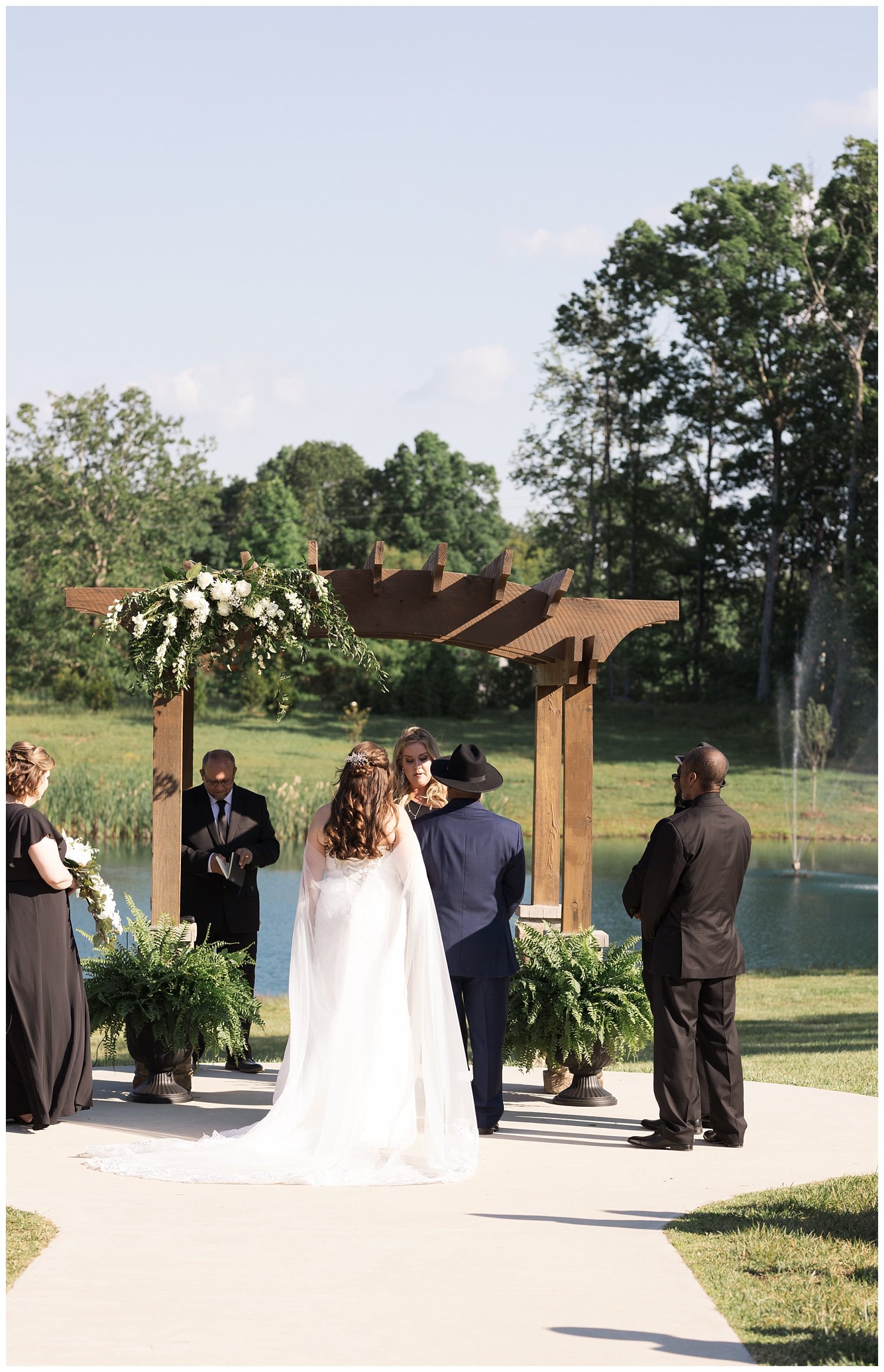 bride and groom standing together at altar at pond