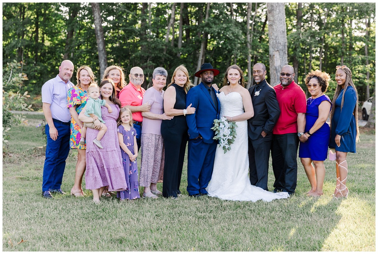 large family posing with bride and groom at wedding