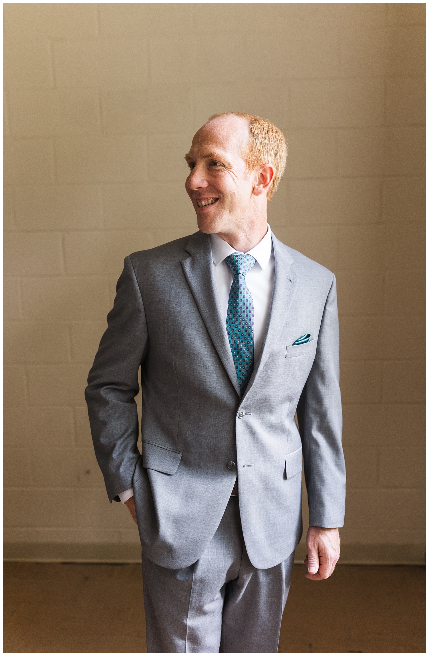 groom posing in his suit while getting ready