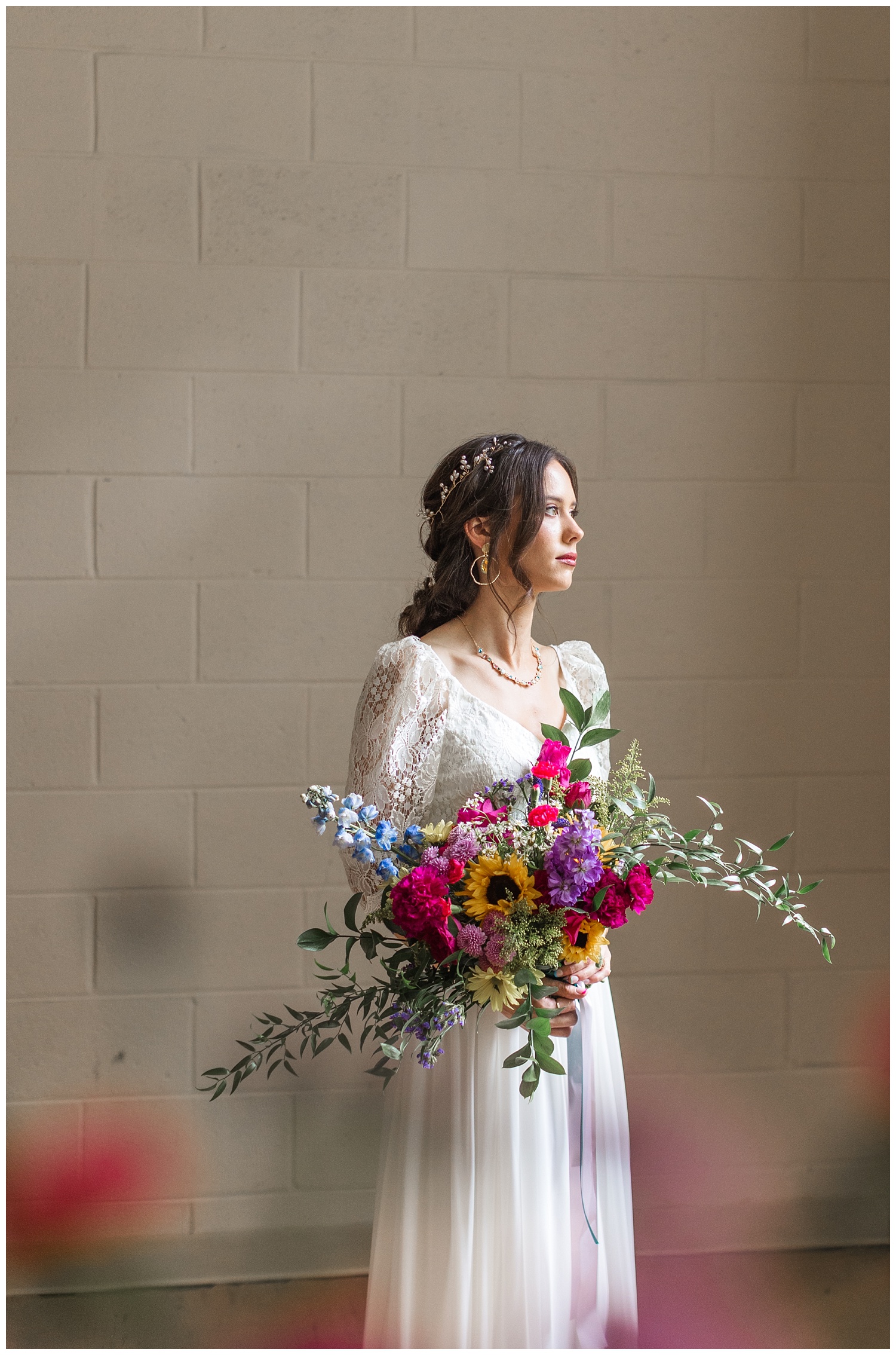 bride holding her bouquet standing in front of a window