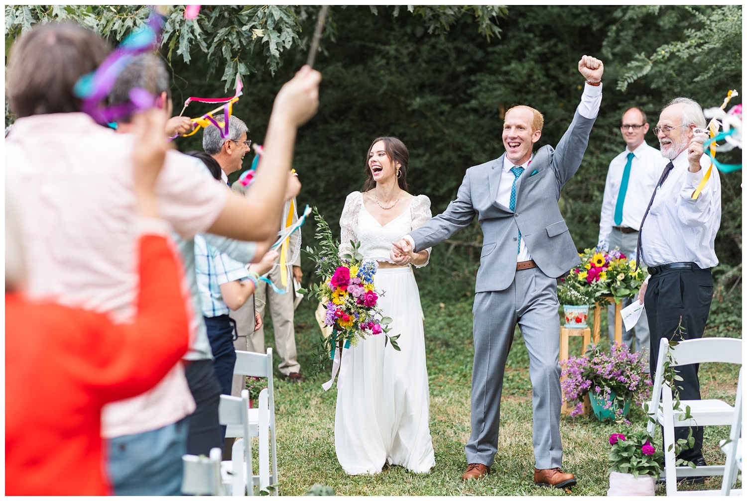 groom cheers while walking back down the aisle after wedding