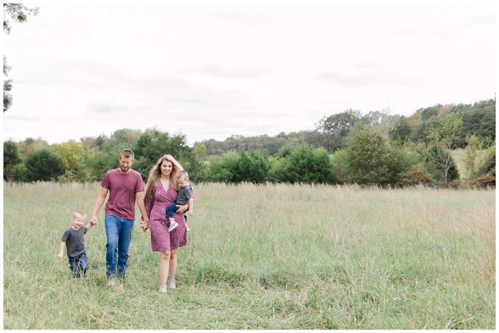 family walking together in a field at fall mini session in Chattanooga