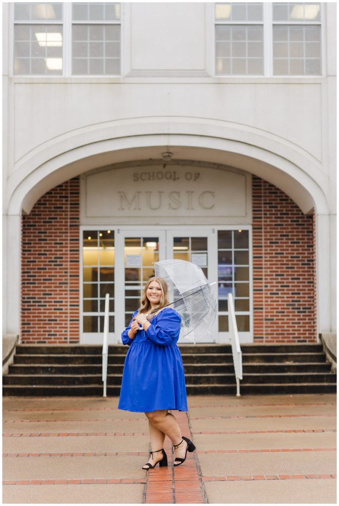 college senior holding a clear umbrella for a rainy photo session 