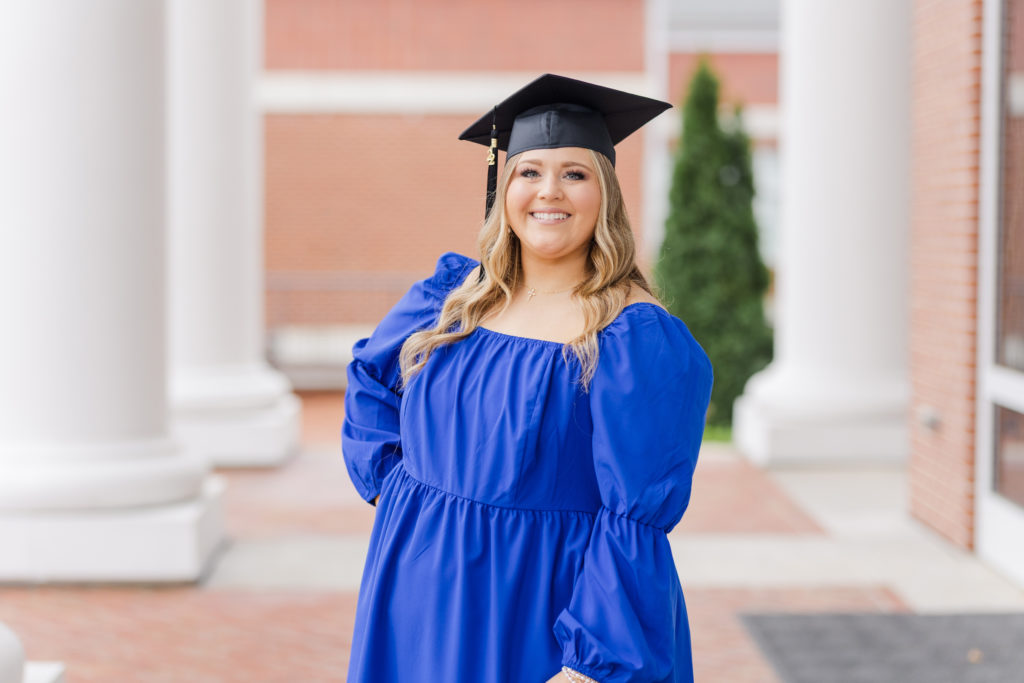 college senior wearing a blue dress and graduation cap at Lee University
