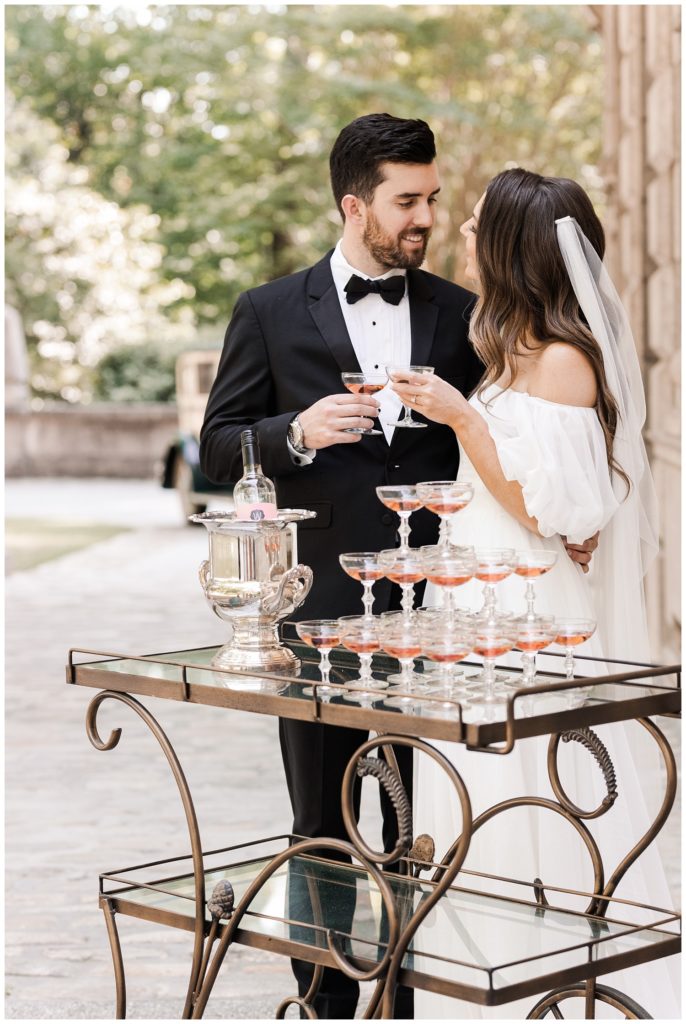 wedding couple holding champagne glasses at the Swan House