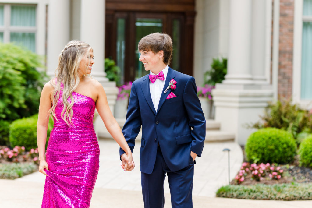 prom couple holding hands matching in hot pink in Chattanooga