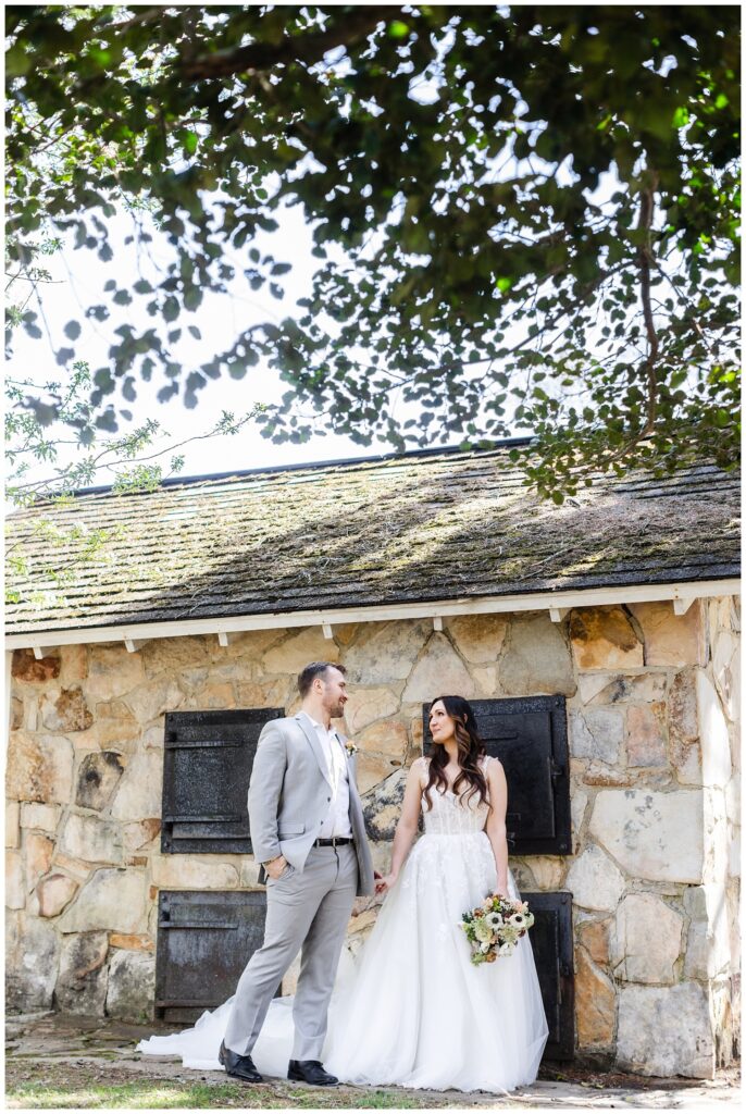 bride and groom walking in front of a stone building at Chattanooga wedding venue