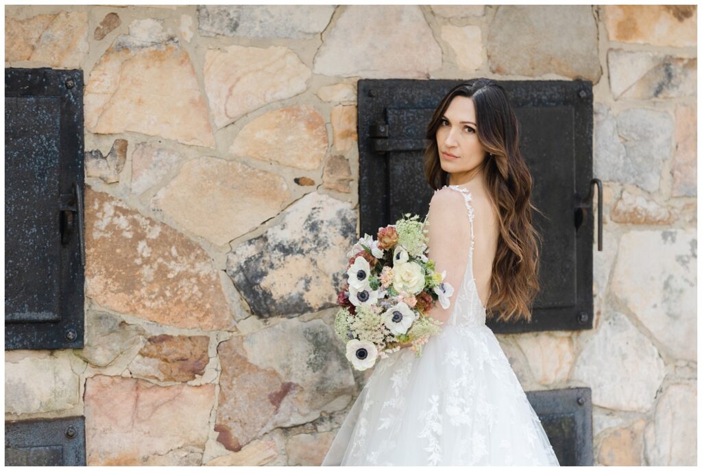bride holding a wedding bouquet with her back to the camera