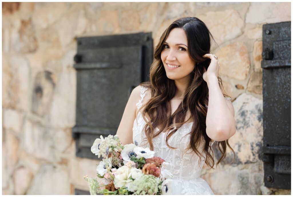 bride smiling at the camera holding her wedding flowers