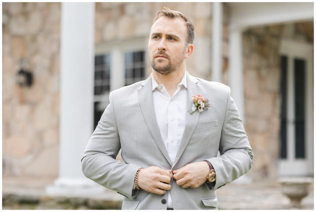 groom buttoning his gray suit at Chattanooga wedding styled shoot