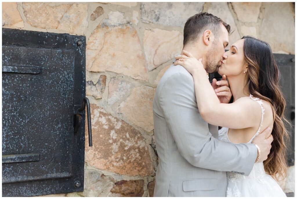 wedding couple kissing in front of a stone building in Chattanooga