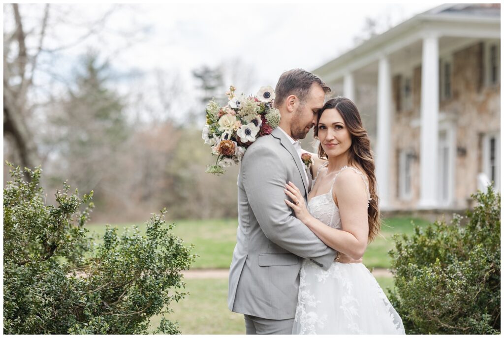wedding couple standing in between bushes at styled shoot