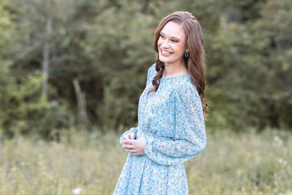 high school senior wearing a blue dress standing in a field in Chattanooga