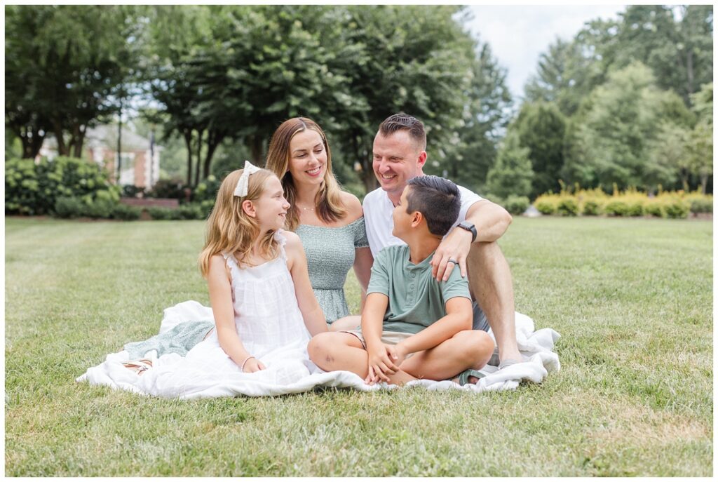family sitting on a white blanket at Lee University session