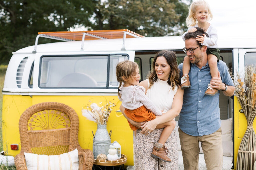 family posing in front a yellow bus for a mini session