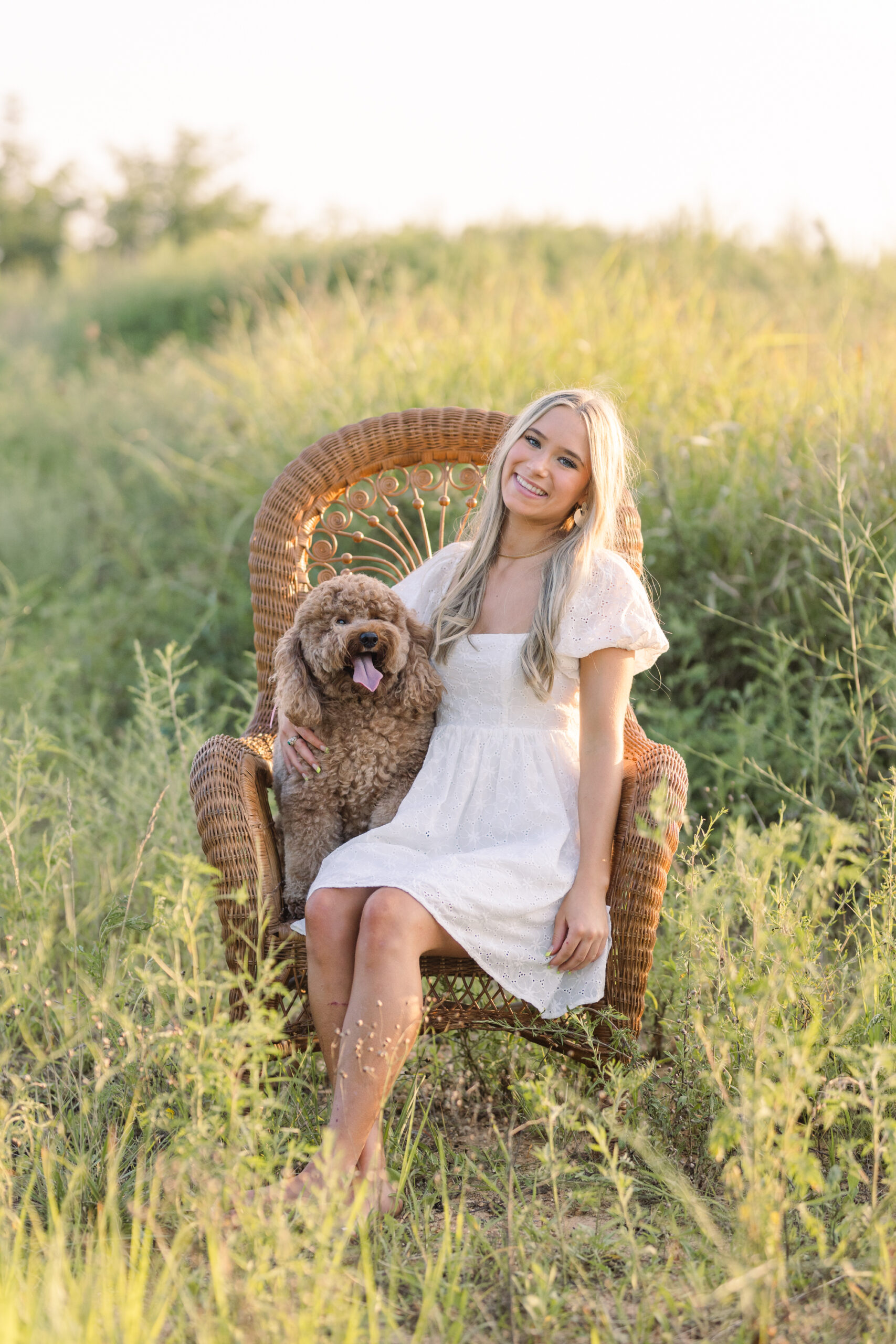 senior sitting next to her puppy in a field