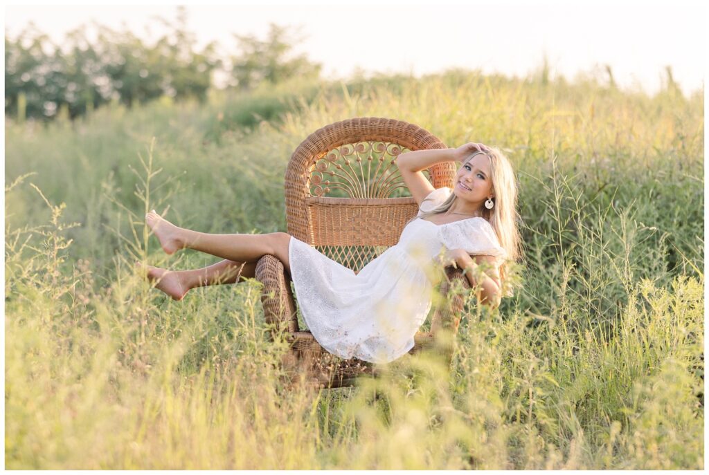high school senior laying across a chair in a field in Chattanooga