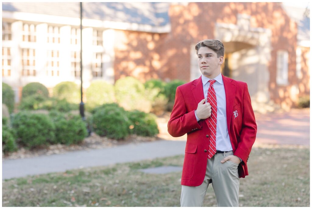 boy posing in a red jacket on the campus of Baylor School
