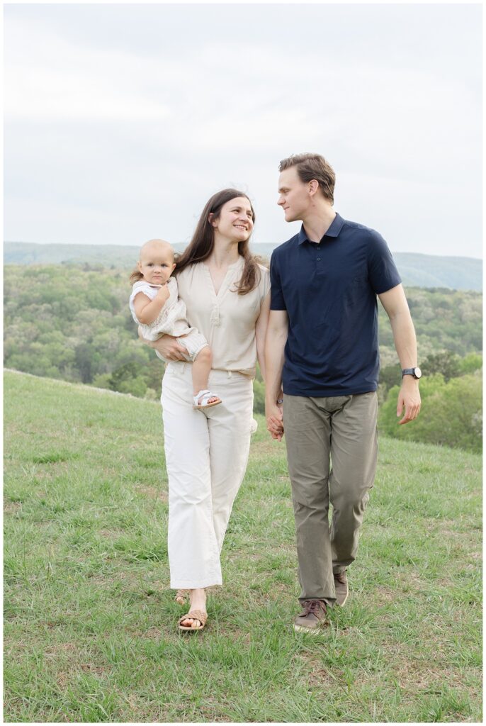 couple walking with their one year old daughter at Raccoon Mountain family session