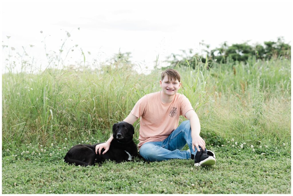 senior session with a black dog in a field in downtown Chattanooga