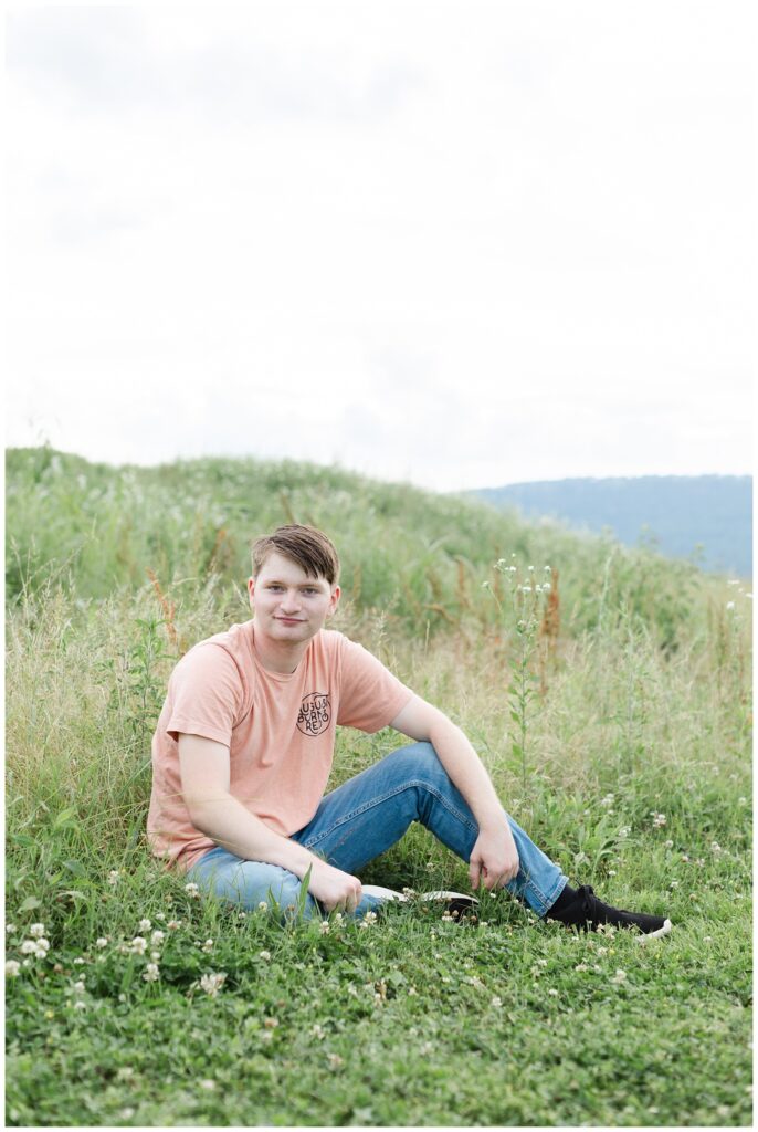 boy posing on the ground in a field at Chattanooga senior session