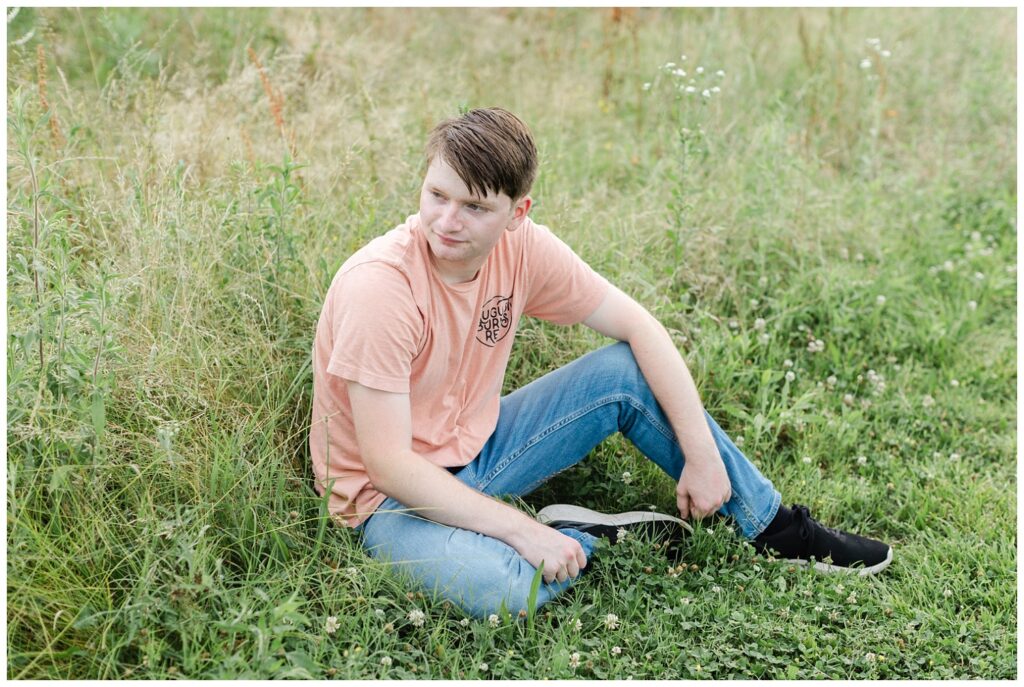 boy posing on the ground in a field at Chattanooga senior session