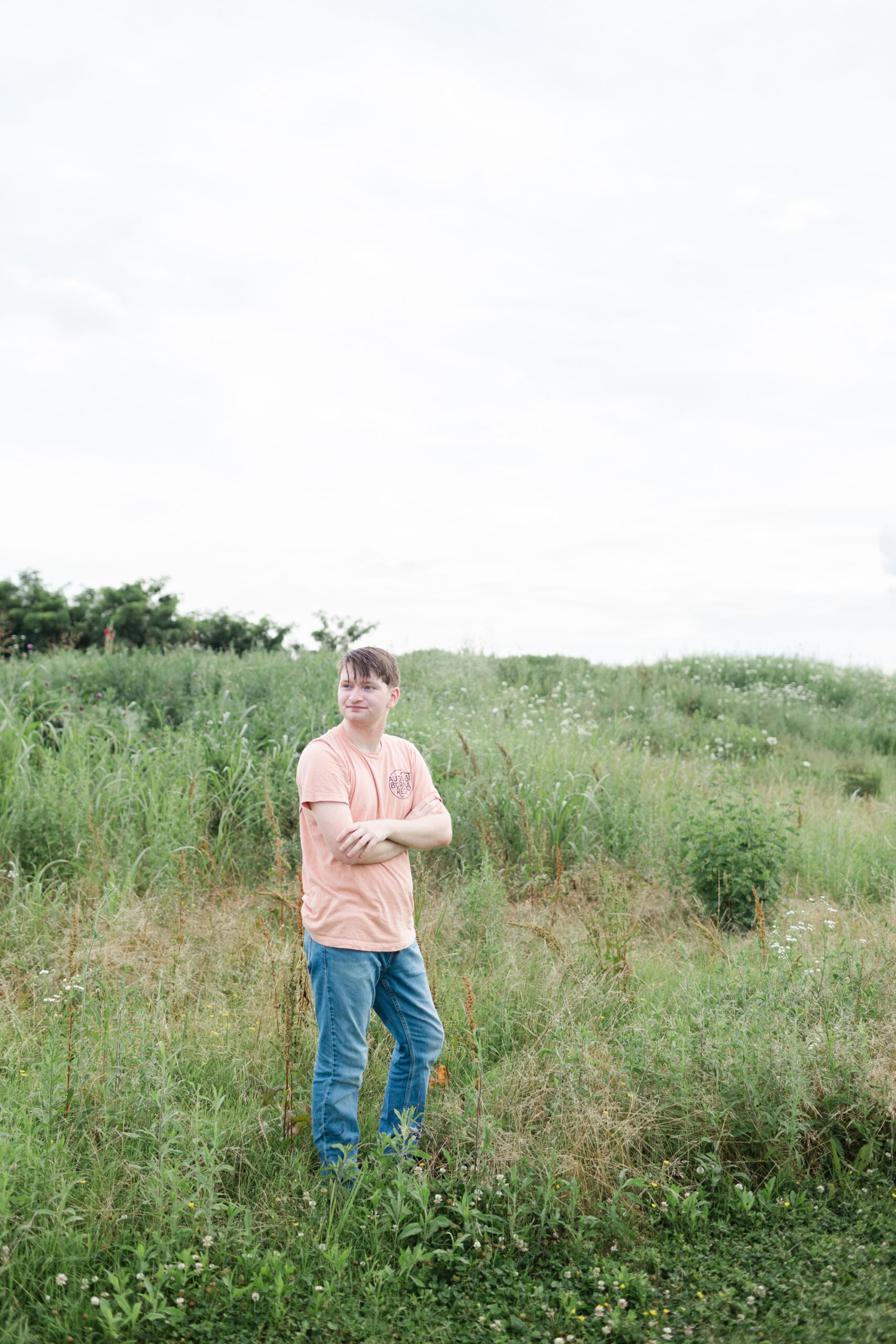 high school senior posing in a field for photoshoot