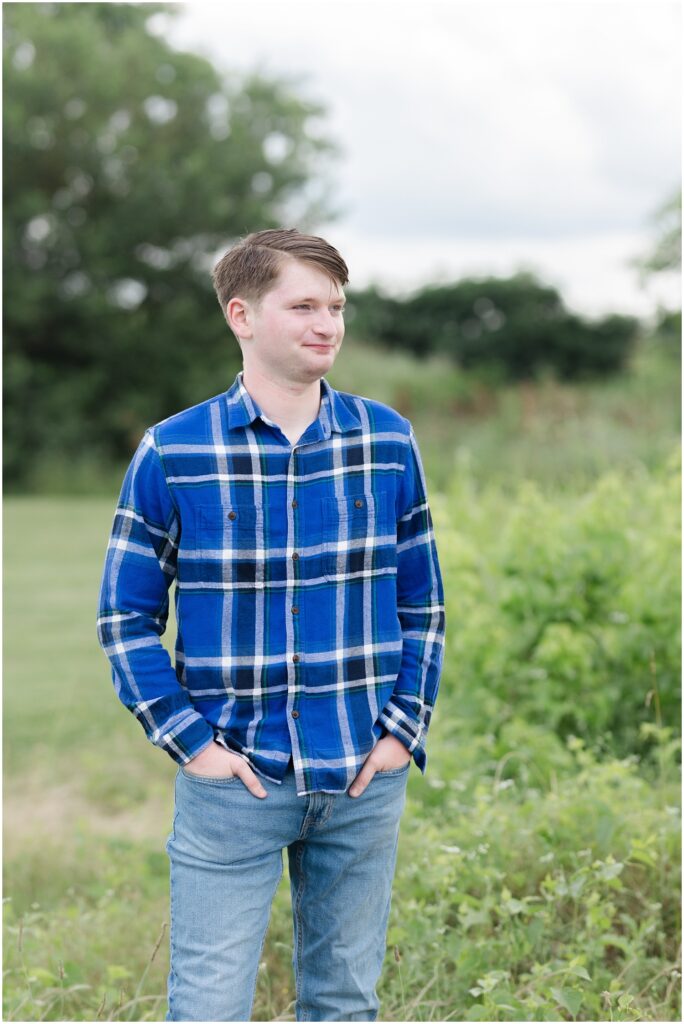 senior boy looking off while posing in a field in downtown Chattanooga