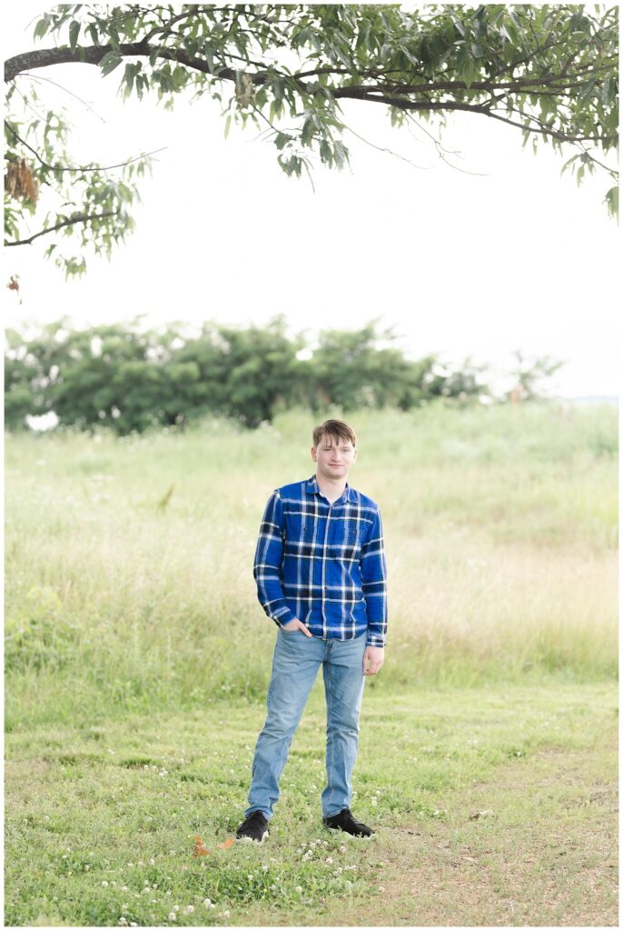 high school senior standing under a tree at the Sculpture Fields