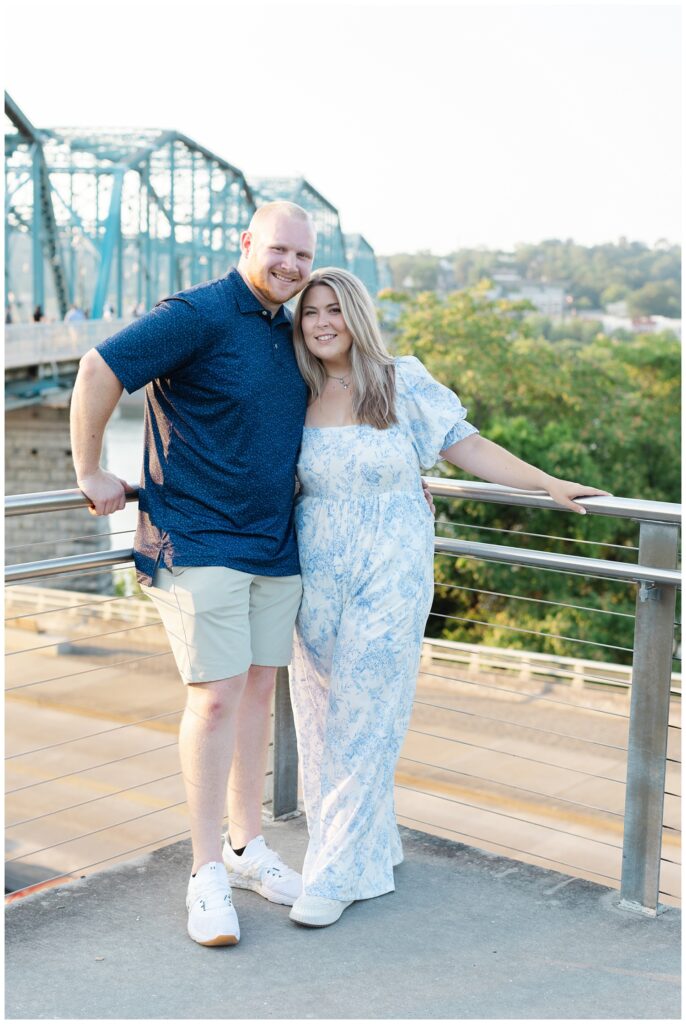 engaged couple leaning against a steel railing in downtown Chattanooga