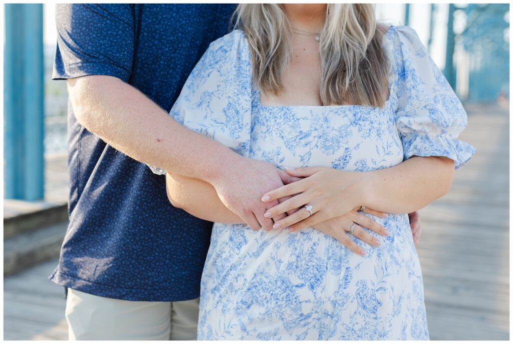 close up detail of woman and man's arms wrapped together showing engagement ring