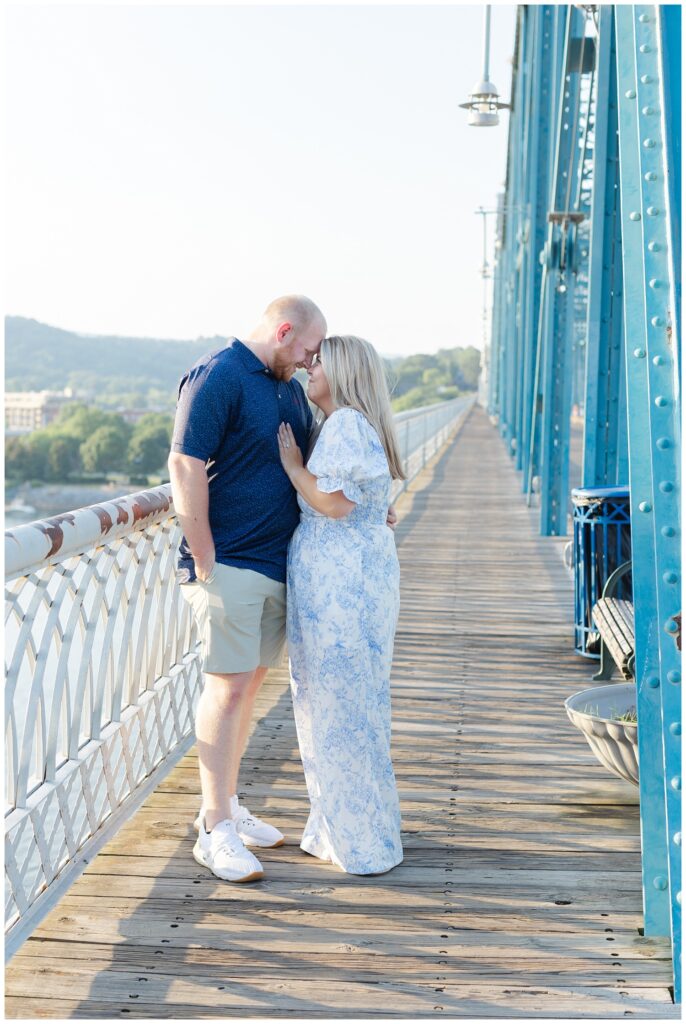 couple posing along the white railing on the Walnut Street Bridge in Chattanooga