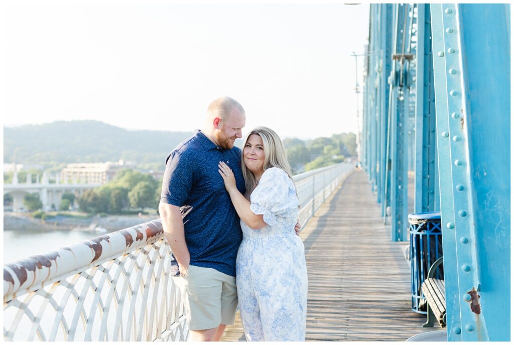 couple posing along the white railing on the Walnut Street Bridge in Chattanooga