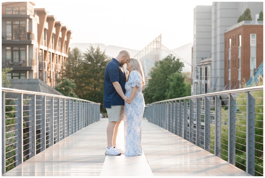 couple posing and holding hands in the middle of the Holmberg Bridge