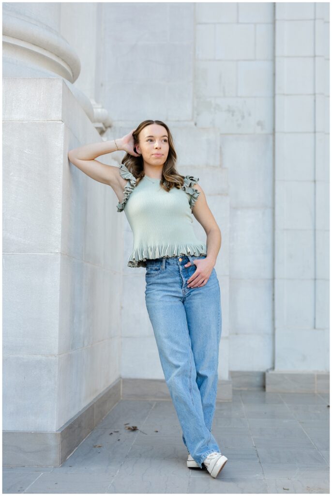 high school senior leaning against a stone wall at the Chattanooga courthouse