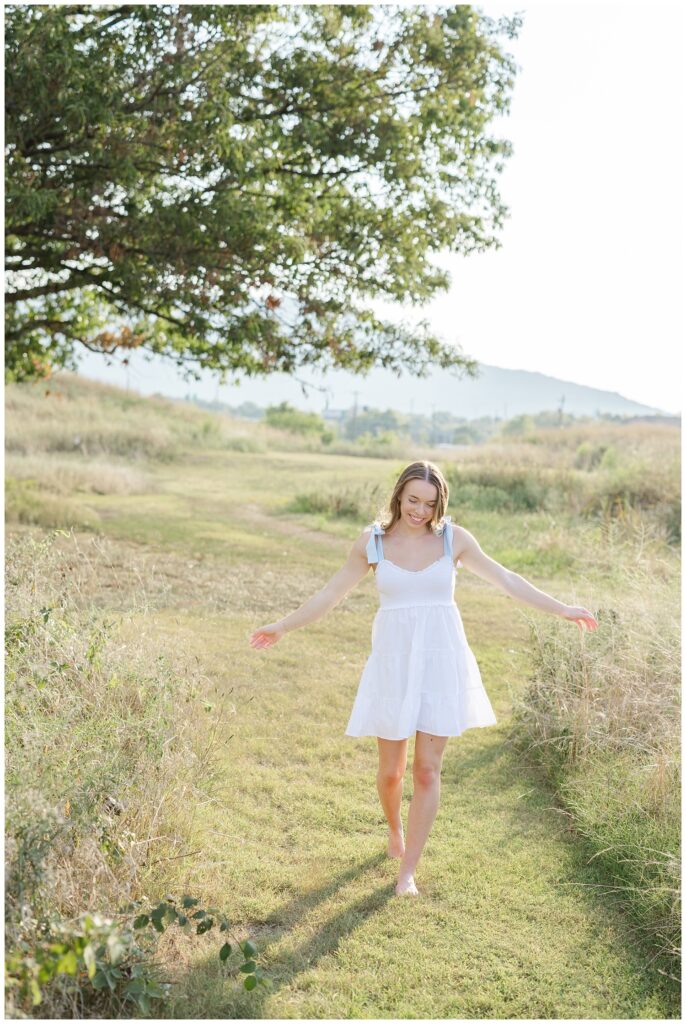 Chattanooga senior girl walking in between the grass at summer photoshoot