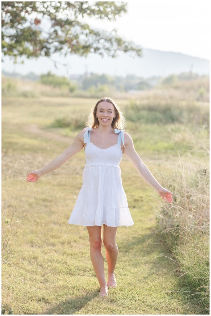 senior girl walking along the grass at summer session in Chattanooga