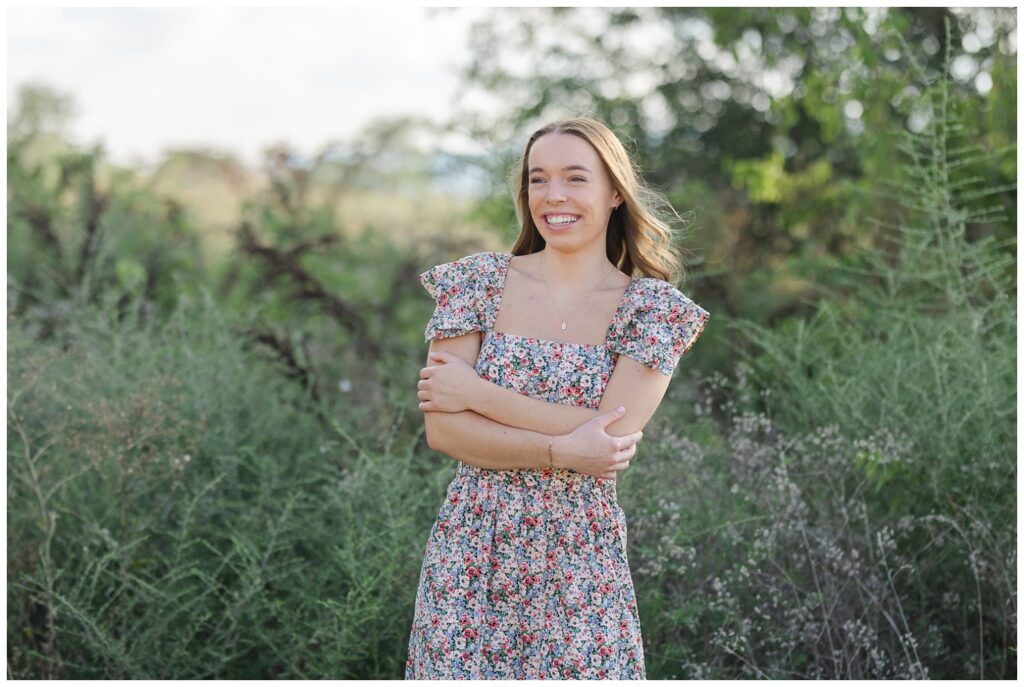 girl laughing and crossing her arms at Sculpture fields senior session