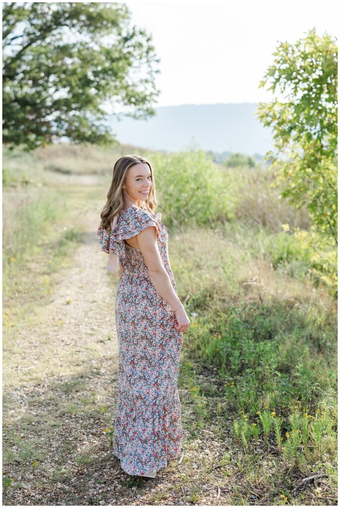 senior girl posing in a floral dress on a trail in Chattanooga