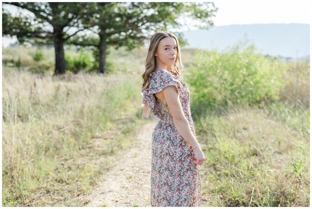 senior girl posing in a floral dress on a trail in Chattanooga