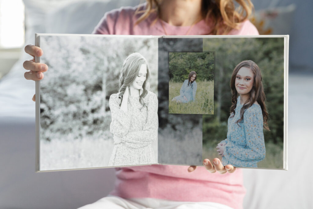 Chattanooga senior photographer holding an album of senior photos 