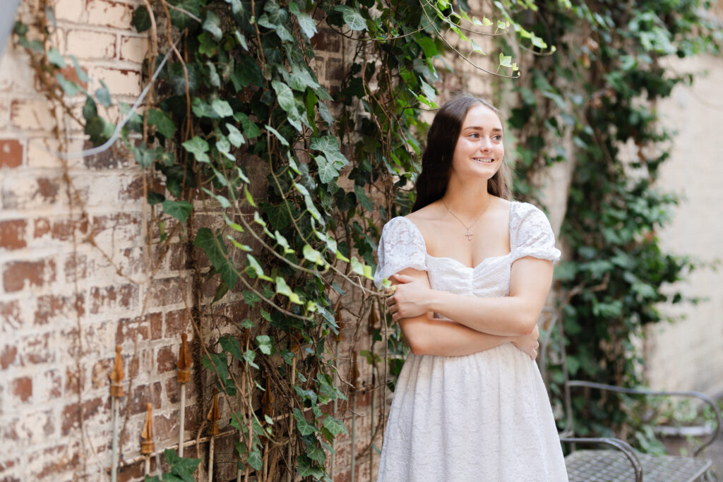 senior girl standing next to a brick wall with ivy in Chattanooga