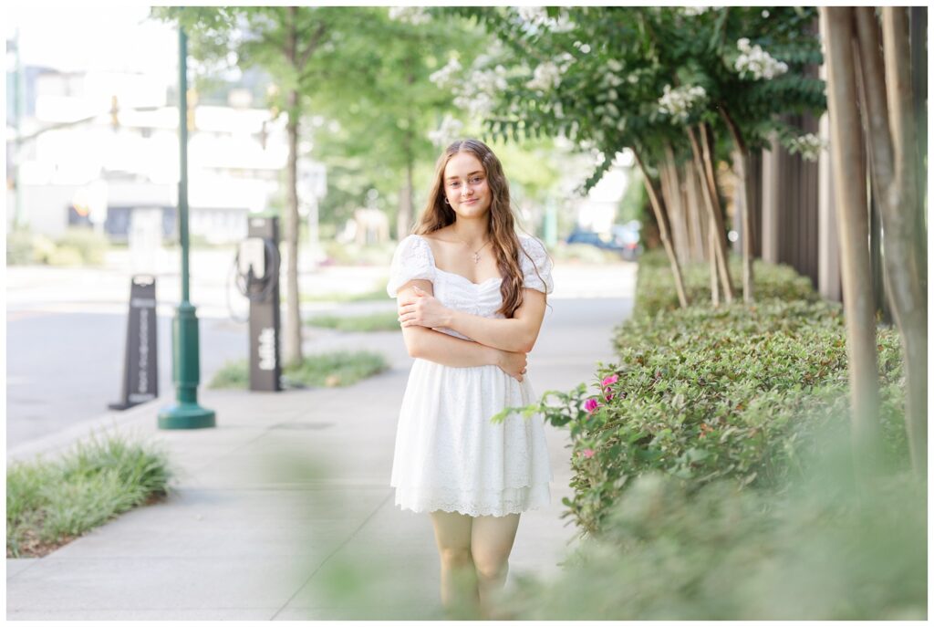 high school senior crossing her arms while posing on a sidewalk in Chattanooga