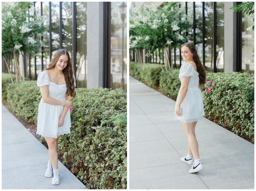 senior girl walking next to some large windows in the West Village outside 