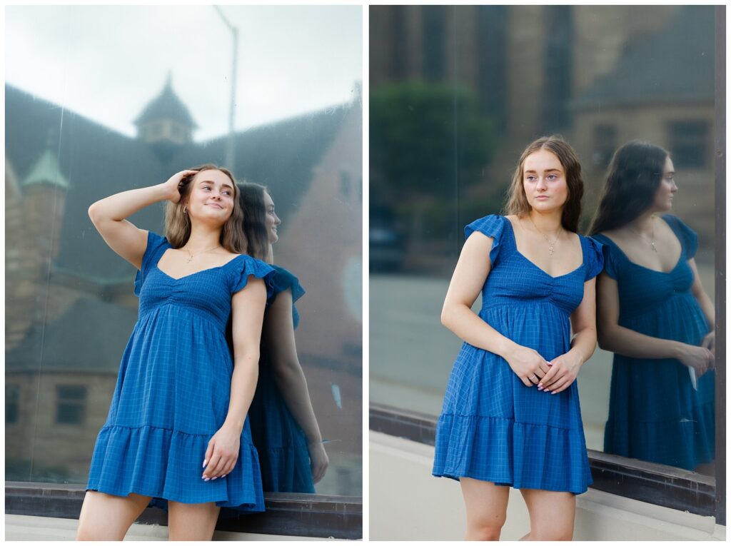 girl leaning her back against a large window outside with her hands in her hair