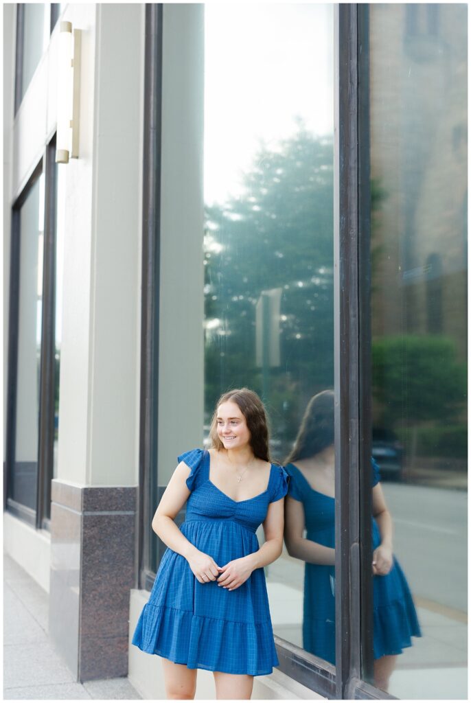 Chattanooga senior photographer with girl leaning against a large window outside 